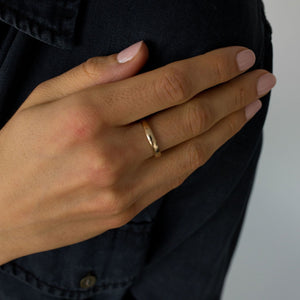 Model wearing the unisex 14k solid gold band engravable band