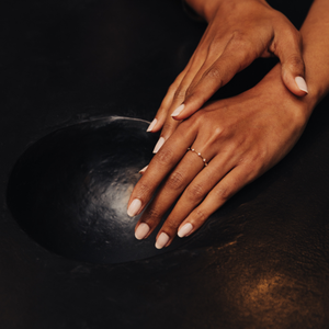 Model wearing a thin 14k gold ring with diamonds