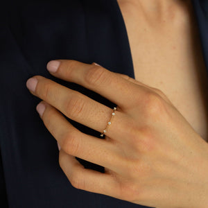 Model wearing a thin 14k gold ring with diamonds