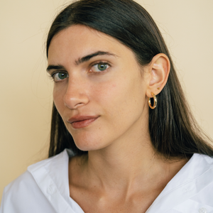 Model wearing 14k semi-hollow chunky gold hoops 