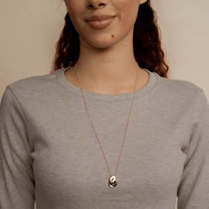 Model wearing 14k solid gold textured worry stone necklace 